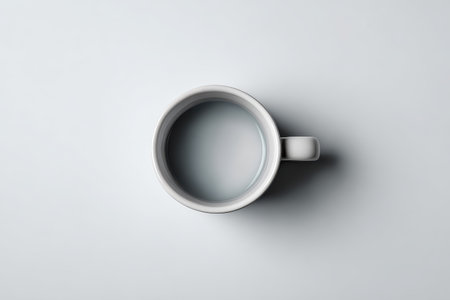A minimalist composition featuring a white coffee mug filled with water, set against a soft gray background. The serene image evokes calm and simplicity.の素材