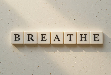 A serene image featuring letter tiles arranged to spell "Breathe" on a smooth surface. This visual encourages mindfulness and promotes relaxation, making it ideal for wellness themes.の素材