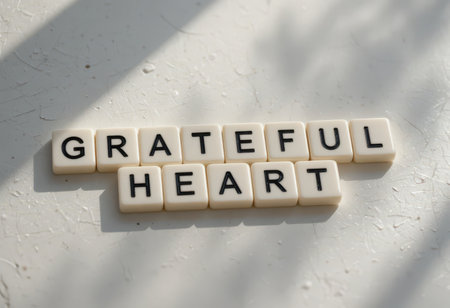 A close-up shot of letter tiles forming the message "GRATEFUL HEART" on a bright surface, symbolizing appreciation, positivity, and mindfulness in daily life.の素材