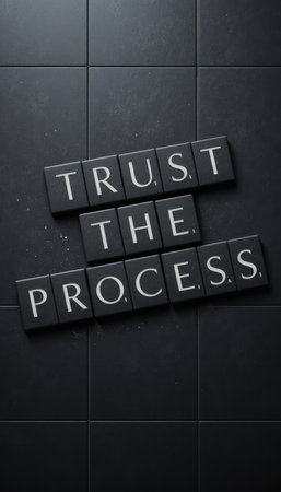 This image features black tiles arranged in a stylish layout with the phrase "Trust the Process." It serves as an inspiring visual reminder of perseverance and dedication in the journey towards success.の素材