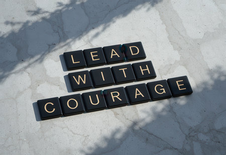 Inspirational phrase "Lead with Courage" displayed on tiles, symbolizing empowerment and strength for leaders seeking to motivate and inspire others.の素材