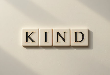 This image features tiles forming the word "KIND" in a serene and minimalistic setting. Soft shadows enhance the calm ambiance, making it perfect for inspirational decor.の素材