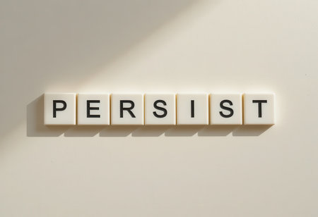 A creative arrangement of letter tiles spells the word 'PERSIST' on a soft, light background. This image symbolizes motivation and determination for personal growth.の素材