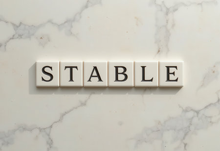 A minimalist arrangement of white tiles spelling the word "stable" on a smooth marble background, emphasizing simplicity and elegance in design. Perfect for modern decor and inspiration.の素材