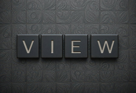 A close-up image of black tiles featuring silver letters that spell the word "VIEW." The textured background offers a modern and stylish visual appeal.の素材