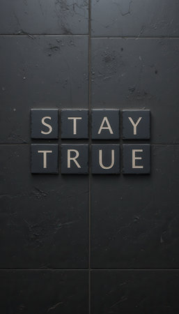 A close-up of black tiles showcasing the words "Stay True," emphasizing simplicity and motivation in a stylish, modern design perfect for home or office decor.の素材