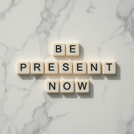 Inspirational flat lay of letter tiles forming the phrase "Be Present Now" on a marble surface, perfect for wellness and mindfulness themes.の素材