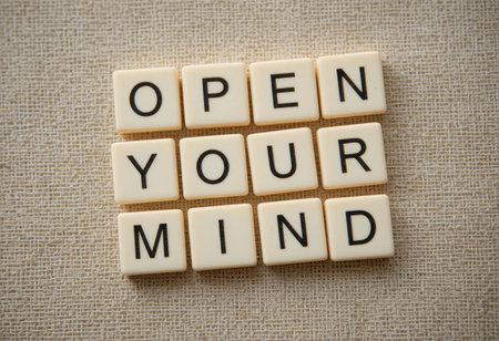 A creative arrangement of lettered tiles spelling "Open Your Mind" promotes personal growth and inspiration. Ideal for motivational content or self-improvement themes.の素材