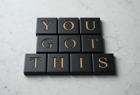 A flat lay of black tiles displaying the motivational words "YOU GOT THIS." This composition inspires positivity and determination, perfect for personal growth projects.の素材