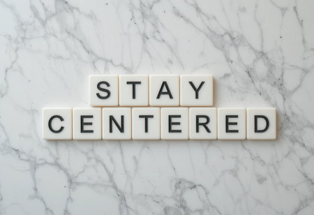 Two words "Stay Centered" made from tiles on a stylish white marble background, ideal for conveying messages of mindfulness, positivity, and balance in personal spaces.の素材