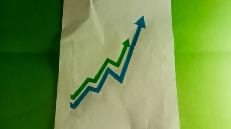 Green graph growing up on green paper background. Business success concept.