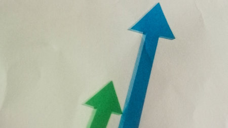 Green and blue arrows pointing up on white paper. Business concept.