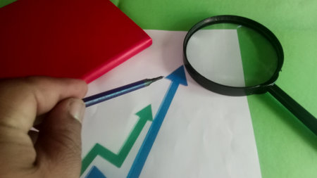 Magnifying glass and red notebook on the flag of Nigeria. The concept of economic growthの写真素材