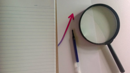 Magnifying glass and pen on the notebook with copy space for add text