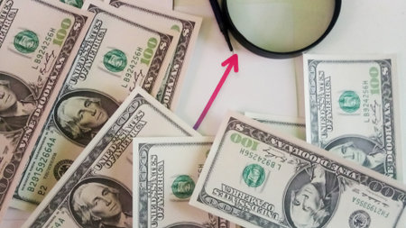 Dollars and magnifier on the background of the dollar.の写真素材