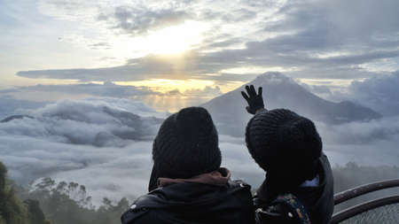 Wonosobo, Indonesia, December - 23 - 2019 . Dieng , two girls are enjoying a vacation, they are on a Sikunir hill enjoying the sunrise and mountain viewsのeditorial素材