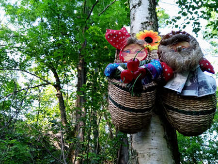 Slavic bast shoes amulets hang on a tree in the forestの写真素材