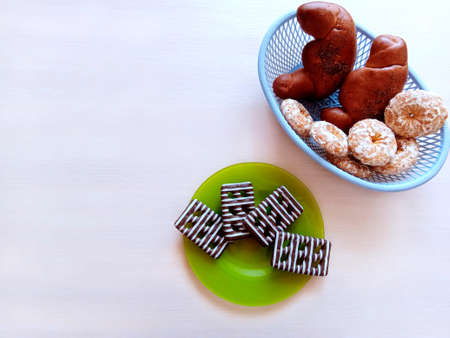 Buns with poppy seeds and gingerbread cookies on a white table. View from aboveの写真素材