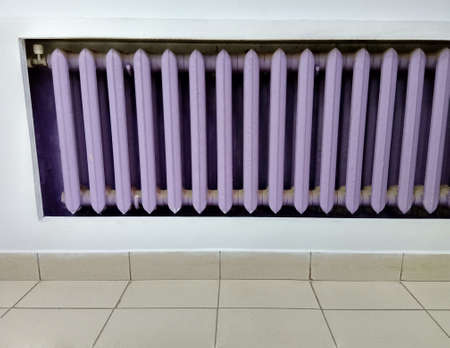 Purple cast-iron battery with background wallの写真素材