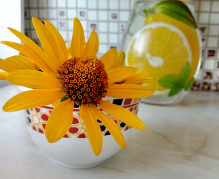Yellow daisy on the table next to the jugの写真素材