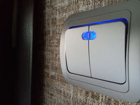 On the wall switch with LED backlight. Close-upの写真素材