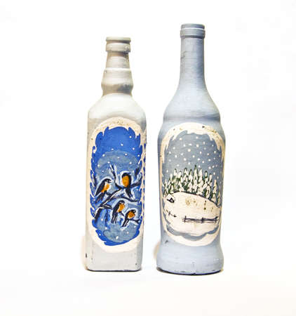 Two bottles hand painted with pictures of winter landscapes.の写真素材