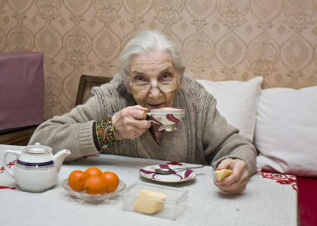 Old lady (European) drinking tea at home.の写真素材