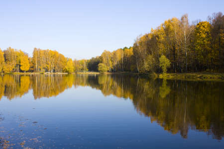 Autumn landscape, lake and forest on bank, reflection in water. の写真素材
