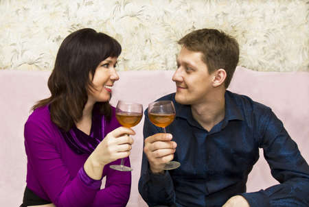 Young couple European drinking wine at home.の写真素材