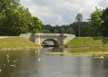 Bridge in park near king's palace in town Gatchina in surroundings of St. Petersburg in Russia.の写真素材