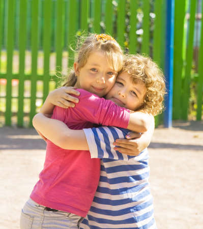 Boy and girl Caucasian standing on yard embracing, summer.の写真素材