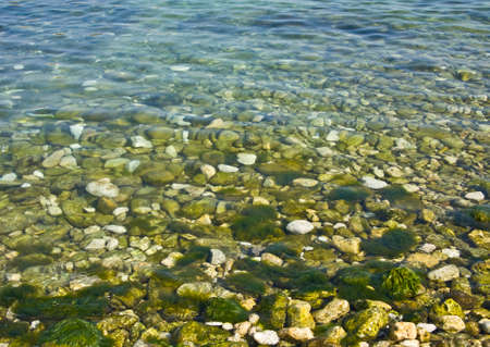 Sea landscape - many stones in water on shore line 