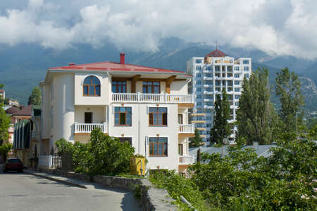 Modern buildings of different types and hills behind in town Yalta, famous resort in region Crimea on Black sea in Ukraine のeditorial素材
