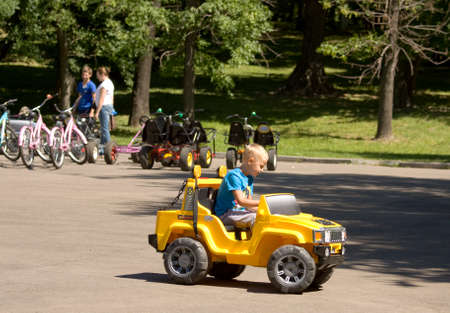 MOSCOW - JUNE 12, 2014: people rest in Lefortovsky park, boy on toy car and people taking bicycles....