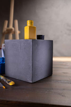 Paint brush and artist tools with cube at wooden table. Paintbrush art painter supplies on desk...