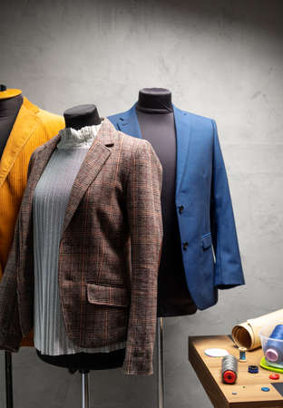 Suit jacket on tailor mannequin and sewing tools. Concept of clothes atelier workplaceの写真素材