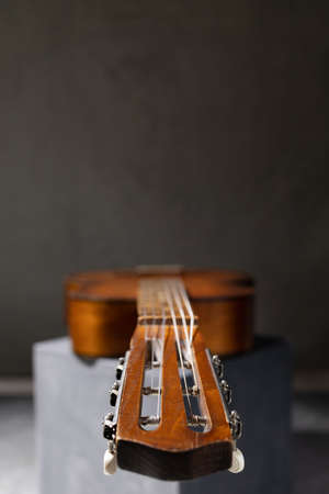 Acoustic guitar at floor. Music concept in studio with classic guitar near wall