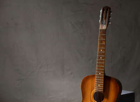 Acoustic guitar at floor. Music concept in studio with classic guitar near wallの写真素材
