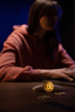 Woman showing bitcoin near laptop computer. Girl and bit coinの写真素材