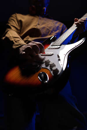 Man playing electric guitar. Musician in record studio holding electric guitarの写真素材