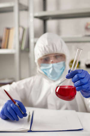 Scientist holding test tube with liquid reagent. Lab scientist and chemical laboratory   glassware