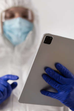Scientist working computer tablet looking at test tube with liquid reagent. Lab scientist and chemical laboratory   glasswareの写真素材