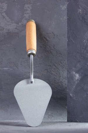 Construction trowel tool at cement  background. Mason tools on concrete wallの写真素材