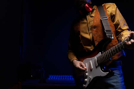 Man playing electric guitar. Musician in record studio holding electric guitarの写真素材