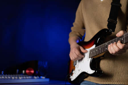 Man playing electric guitar. Musician in record studio holding electric guitar