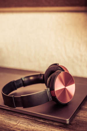 Computer laptop and headphones at table in office.  Workplace for online studyの写真素材