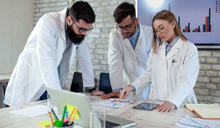 Doctors and medical researchers or scientists on conference meeting, discussing possible solutions for resolving a world health crisis. Health and medical care concept. Selective focus.の写真素材