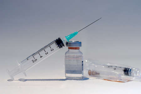 A bottle with vaccine and syringe with needle isolated in white background. Medicine, science and healthcare concept.の写真素材