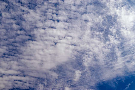 White fluffy clouds on blue sky in summer. Abstract background and texture concept.