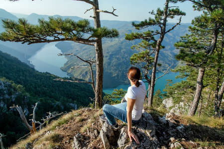 Young female nature explorer enjoying the panoramic view on a canyon of river Drina from Tara...